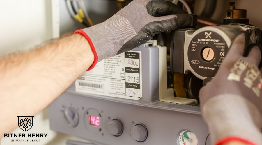 A plumber with gloves fixes dials, gauges, and pipes