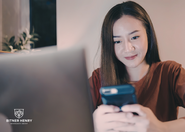 A woman checks her resources on a phone and computer
