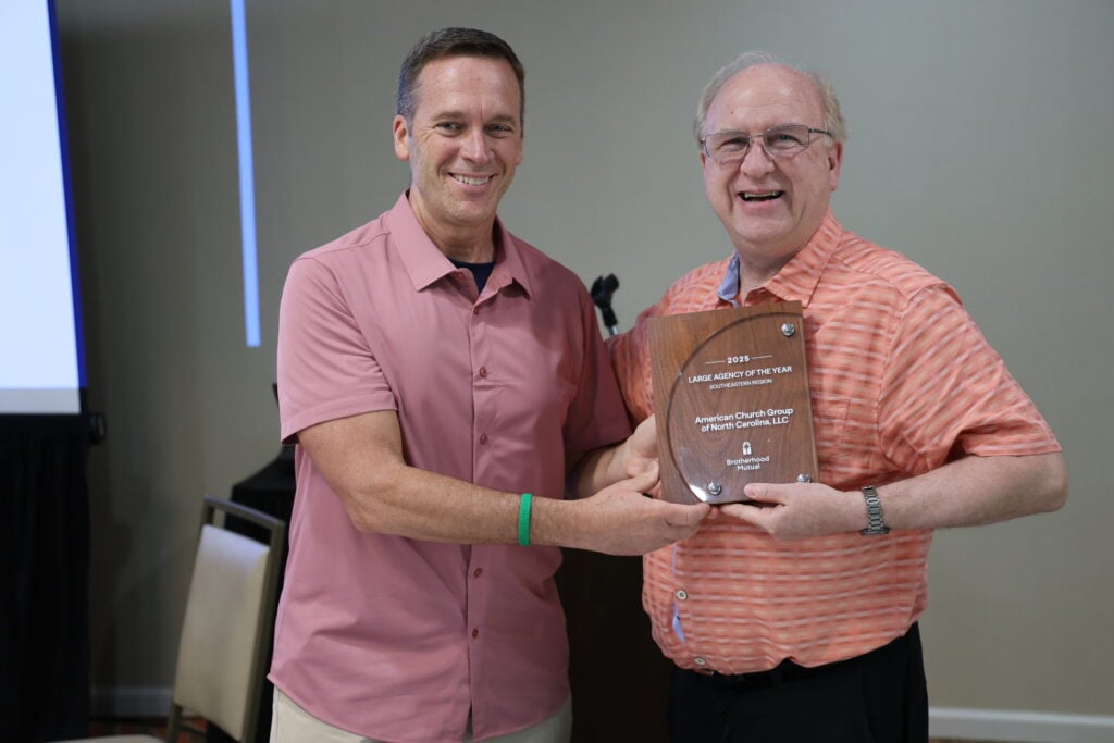 A Brotherhood representative hands agency president Steve Henry the award.